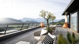 Dachterrasse mit Sitzmöbeln und Blick über grüne Berglandschaft