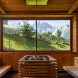 Sauna mit Blick auf grüne Landschaft und Berge