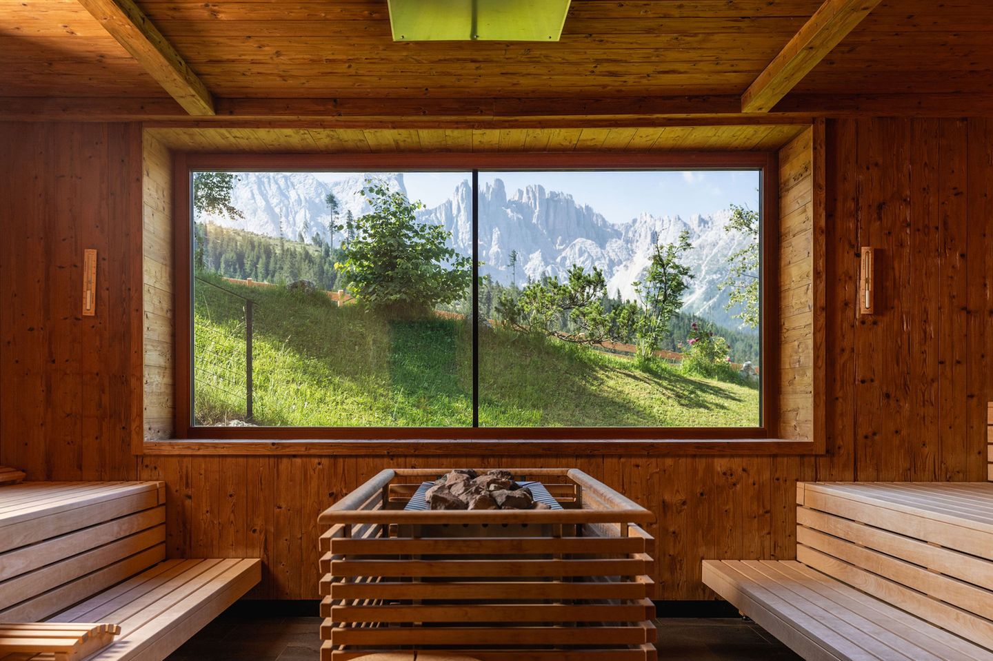 Sauna mit Blick auf grüne Landschaft und Berge