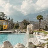 Pool mit Blick auf Berge, rechts zwei Badewannen