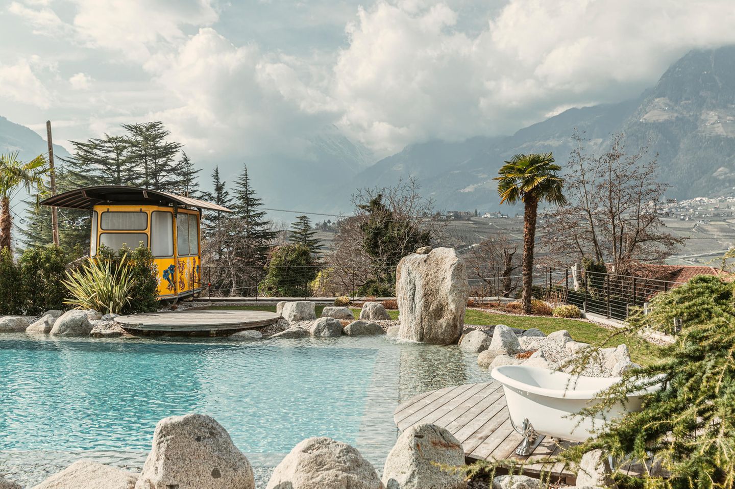 Pool mit Blick auf Berge, rechts zwei Badewannen