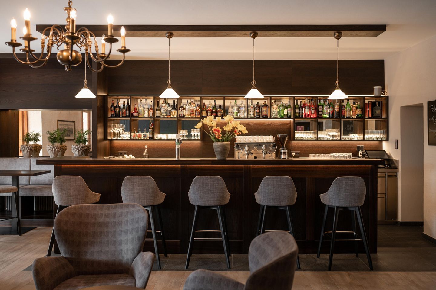 Barhocker vor schlichter Theke, Kronleuchter