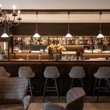 Barhocker vor schlichter Theke, Kronleuchter