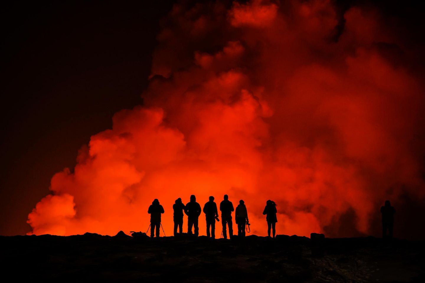 Menschen beobachten und fotografieren den Vulkanausbruch auf Island am 8. Februar 2024