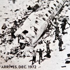 Überlebende neben einem Flugzeugwrack erhalten Rettung