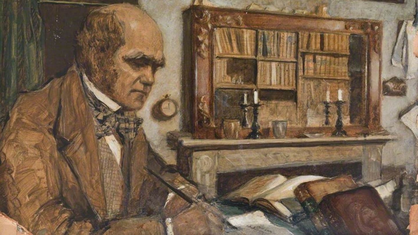 Der Naturforscher Charles Darwin sitzt, umgeben von Büchern, am Schreibtisch in seinem Arbeitszimmer