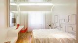 Hotelzimmer in schlichtem Design, ein Bett im Zentrum