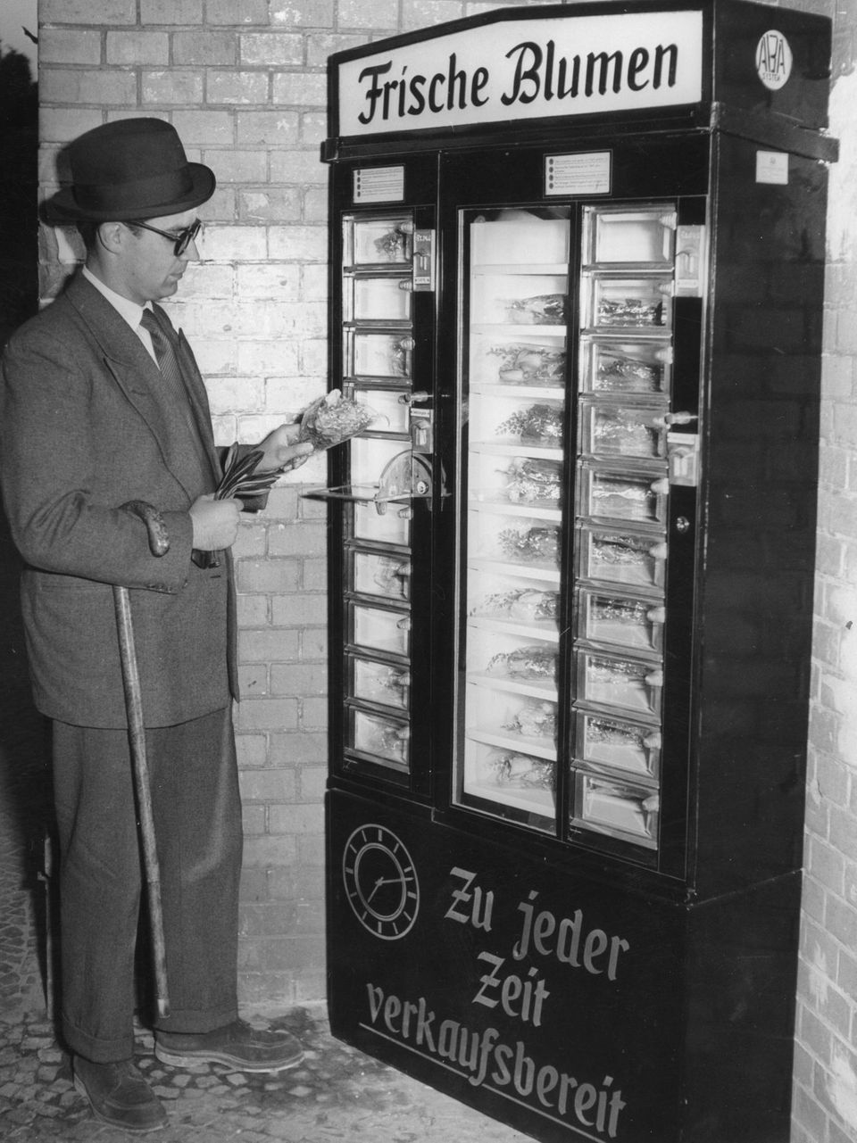 Ein Mann zieht im Jahr 1951 Blumen an einem Automaten
