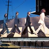 Eine Werbetafel zeigt die Beatles, wie sie hintereinander einen Zebrastreife überqueren