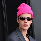 Der Sänger Justin Bieber, porträtiert 2022 mit neonfarbener Mütze und Sonnenbrille