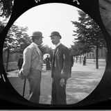 Zwei Männer mit Hüten stehen nebeneinander und reden