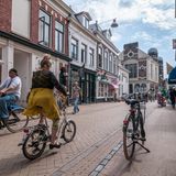 Eine Frau fährt auf dem Fahrrad durch eine Strasse