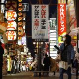 Eine Strasse mit Menschen und Bars und Restaurants in Osaka