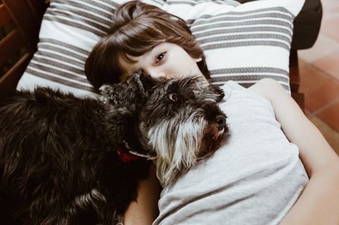 Junge mit Hund auf der Brust