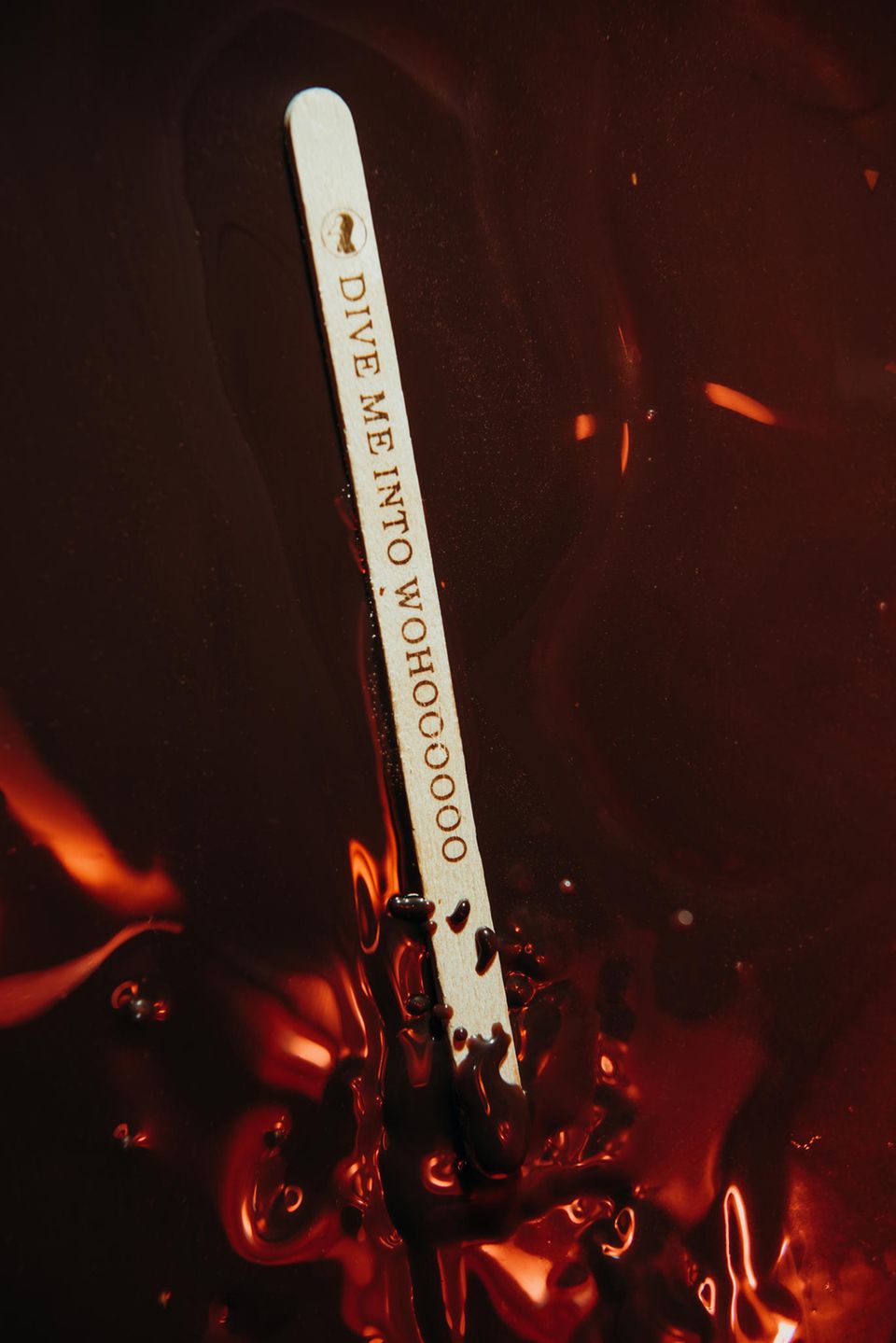 Ein Holzstäbchen zum Probieren von flüssiger Schokolade