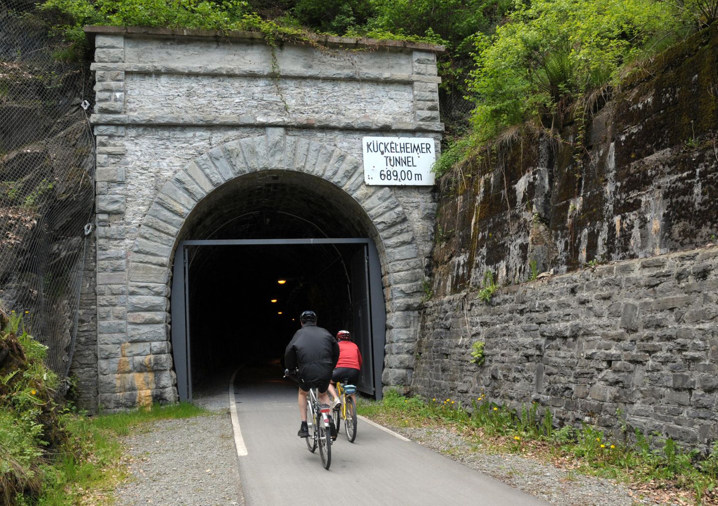 radfahrende Menschen durch den Kückelheimer Tunnel