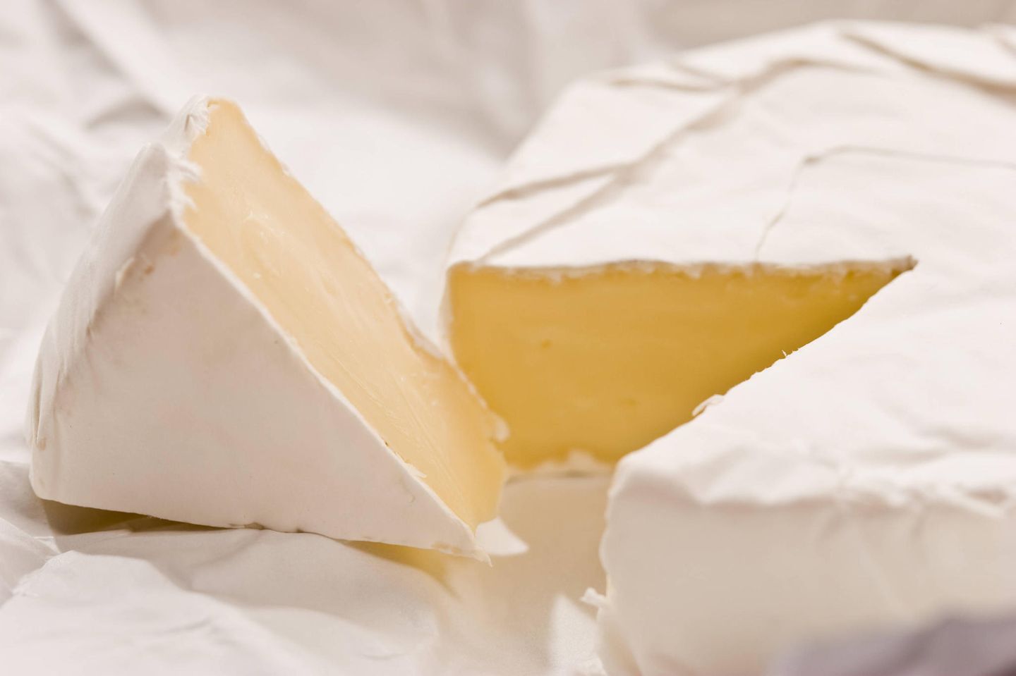 Camembert-Käse in zwei Stücke geschnitten Camembert-Käse in zwei Stücke geschnitten