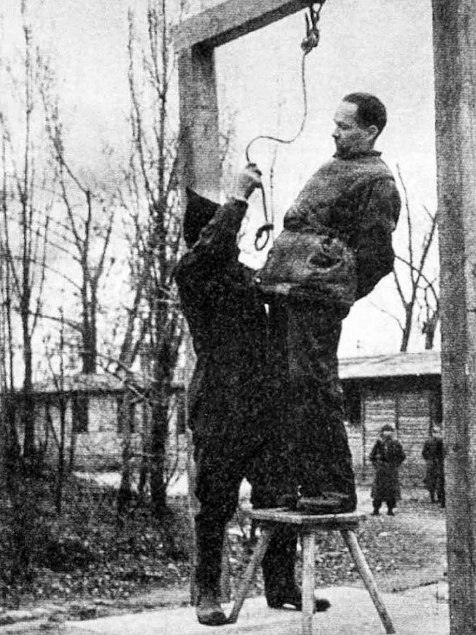 Ein Mann legt Rudolf Höß am Galgen die Schlinge an Ein Mann legt Rudolf Höß am Galgen die Schlinge an