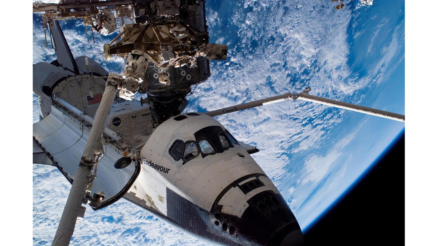 Über 420 Tonnen schwer, 109 Meter lang, fast so geräumig wie ein Jumbojet und gespickt mit 350 000 Sensoren: Die mit Abstand größte Struktur, die die Menschheit bislang im Erdorbit montiert hat, die Internationale Raumstation ISS, ist ein Koloss und ein fragiles Objekt zugleich. Nur wenige Millimeter Aluminium und ein paar schützende Kunststoffschichten trennen die Bewohner*innen vom Vakuum des Weltalls.  Bislang klappt das gut: Seit November 2000 ist die Raumstation, für deren Aufbau und Betrieb sich fünfzehn Staaten zusammengeschlossen haben, permanent bewohnt. Insgesamt 42 Raumflüge, davon allein 37 mit den US-amerikanischen Spaceshuttles, waren nötig, um die Wohnmodule, Solarzellen und weiteren Komponenten in eine Höhe von gut 400 Kilometern zu bringen. Es sollte nicht bei diesen Missionen bleiben: Die Station, auf der im Normalfall sieben Menschen wohnen, forschen und arbeiten, ist wartungsintensiv. Mal fällt eine der Toiletten aus, mal muss ein Raumanzug erneuert werden, mal spielt die Stromversorgung verrückt. Trotzdem soll die ISS bis ins Jahr 2030 den Betrieb durchhalten. Erst dann könnten kleinere, kommerzielle Stationen die Aufgaben des fragilen Kolosses übernehmen.  Im Bild: Die Raumfähre "Endeavour" dockt im August 2007 an die Internationale Raumstation an. Sie liefert einen Teil der tragenden Gitterstruktur. Es ist der 26. Flug zum Aufbau des orbitalen Außenpostens