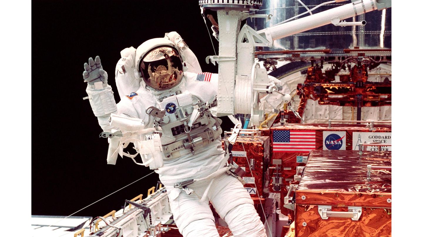 1993: Reparatur in großen Höhen Es hatte ein Triumph werden sollen und wird ein Desaster: Die ersten Bilder, die das neue, sehnsüchtig erwartete Weltraumteleskop Hubble 1990 zurück zur Erde funkt, sind unscharf. Ein Spiegel des rund 1,5 Milliarden Euro teuren Observatoriums ist auf der Erde falsch geschliffen worden. Game over? Nein: Im Dezember 1993 startet eine siebenköpfige Crew mit einem Spaceshuttle ins All und verpasst dem fehlsichtigen Teleskop eine Sehhilfe. Vier weitere Besuche folgen: Astronaut*innen kümmern sich nicht nur um einen besseren Durchblick, sie bringen auch Hubbles wissenschaftliche Instrumente auf den neuesten Stand und tauschen defekte Steuerelemente aus. Der Aufwand lohnt sich. Hubble gelingt es, tiefer und schärfer ins Universum zu blicken als alle Teleskope zuvor. Das Observatorium beobachtet die Geburt von Sternen und Galaxien, es entdeckt ferne Planeten, es spürt Schwarze Löcher auf. Kurz: Hubble revolutioniert die Astronomie. Inzwischen hat ein neues Observatorium, das James-Webb-Weltraumteleskop (JWST), viele Aufgaben des alternden Veteranen übernommen. Während Hubble etwa 500 Kilometer über der Erde kreist, ist JWST allerdings 1,5 Millionen Kilometer entfernt. Kurz hinfliegen, Hand anlegen und dabei freundlich winken ist somit keine Option mehr. Im Bild: US-Astronaut Steven Smith verlässt im Februar 1997 die Raumfähre »Discovery«, um während eines Außeneinsatzes das Weltraumteleskop Hubble (o. r.) zu reparieren