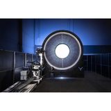 Runde, leuchtende Technik, daneben Geräte und ein Mensch der daneben sehr klein aussieht