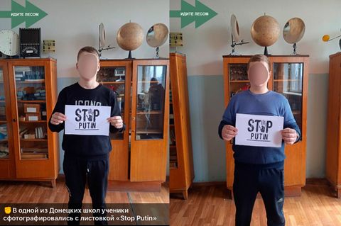Zwei anonymisierte junge Menschen mit selbstgemachtem A4 Papier mit der Aufschrift "Stop Putin"