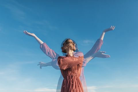 Frau bewegt sich vor blauem Himmel als Doppelbelichtung