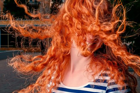 Mädchen mit roten lockigen Haaren lachend