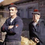 Zwei Männer stehen an einem Heuballen