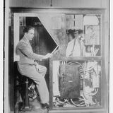 Mann in Anzug sitzt in einer altmodischen Fotokabine