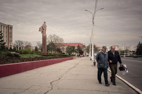 Zwei Männer laufen auf einem Boulevard vor dem Regierungsgebäude