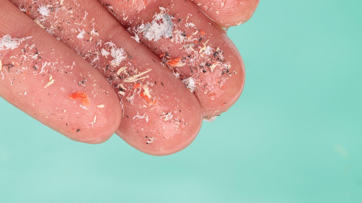 Nahaufnahme einer Hand, darauf kleine Schmutzpartikel Nahaufnahme einer Hand, darauf kleine Schmutzpartikel