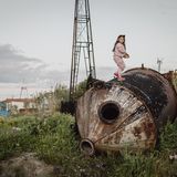 Ein Mädchen klettert auf einem Öl Tank