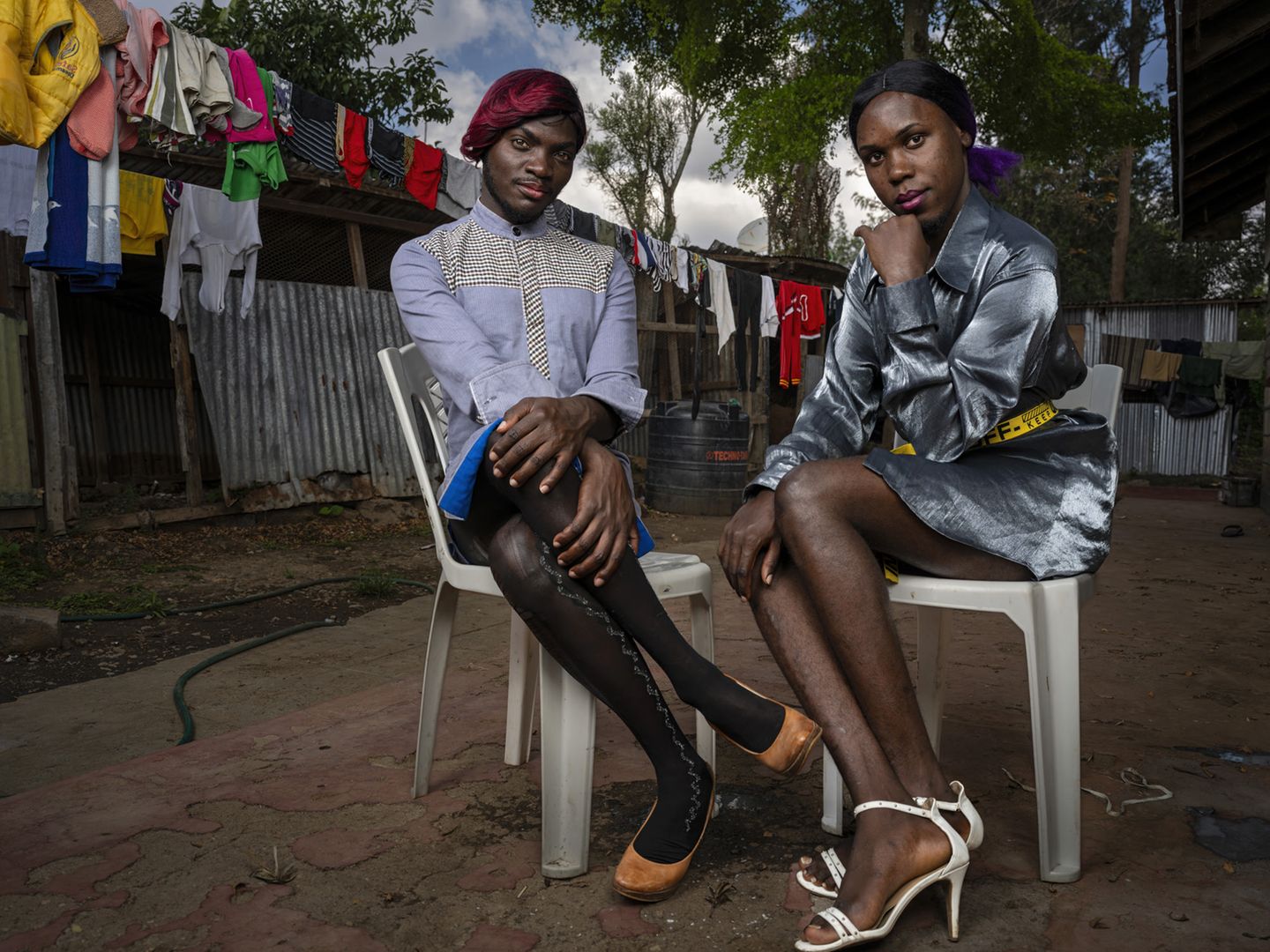 Zwei Personen in Uganda sitzen in einem Innenhof. Beide wurden zuvor für ihr Trans Leben eingesperrt