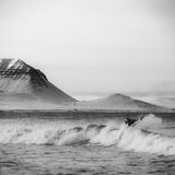 Surfer in Island vor einer Bergkulisse