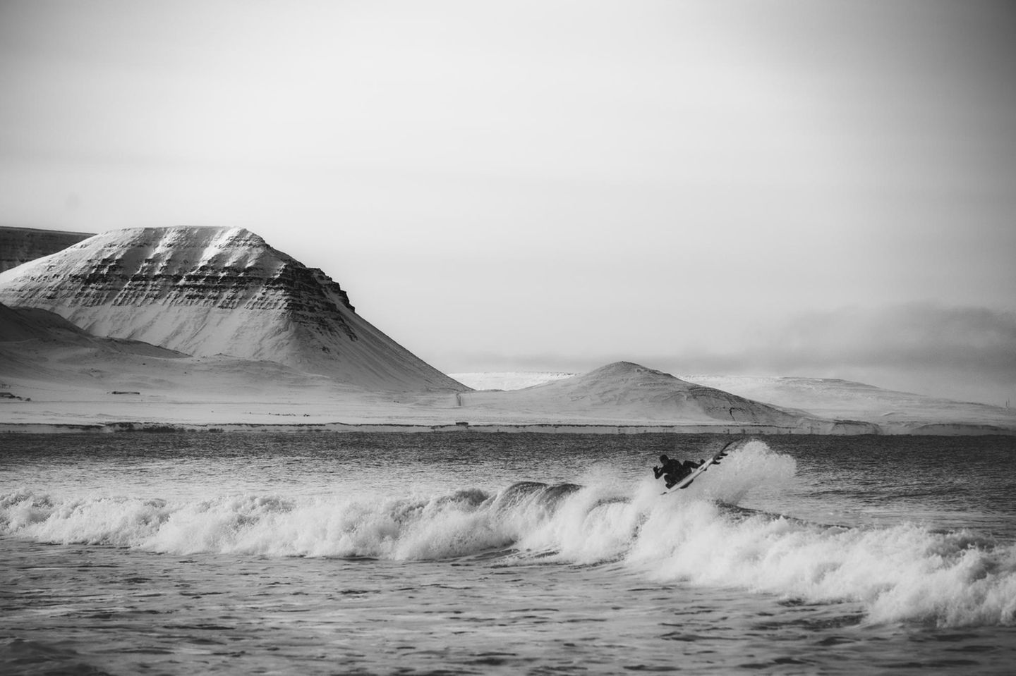 Surfer in Island vor einer Bergkulisse