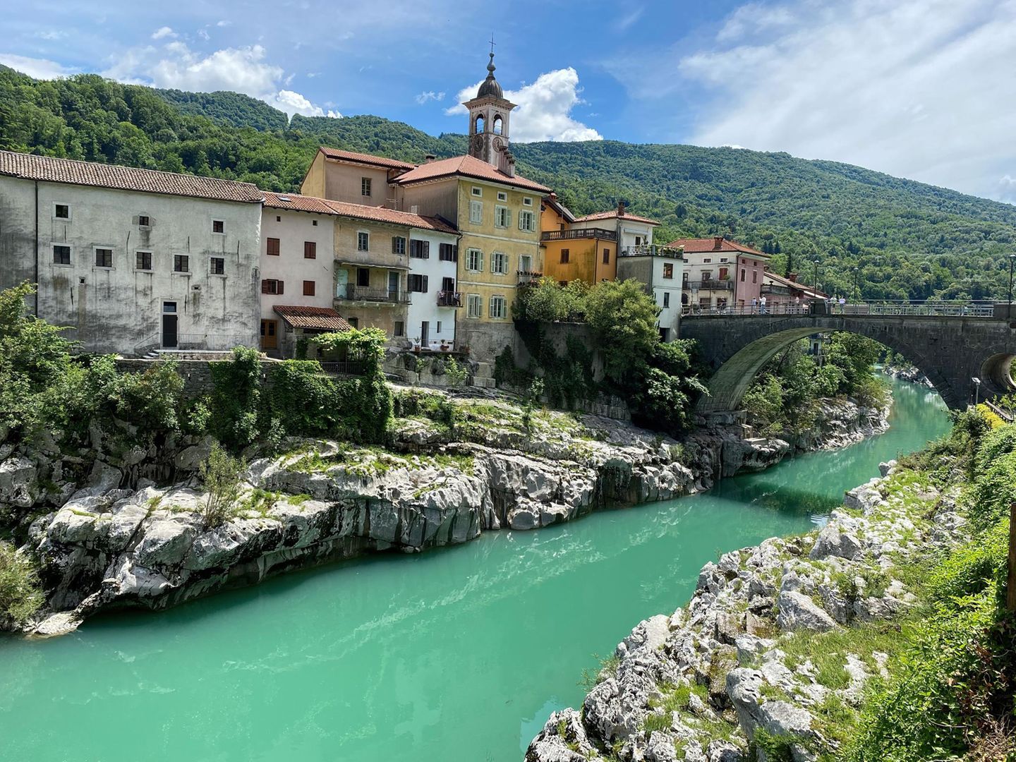Bunte häuser und Kirchturm, hohe alte Steinbrücke, unten der Fluss