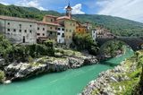 Bunte häuser und Kirchturm, hohe alte Steinbrücke, unten der Fluss