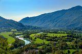 Breites Tal mit Fluss und Bergen im Hintergrund