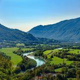 Breites Tal mit Fluss und Bergen im Hintergrund