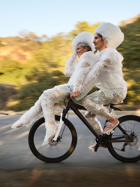 zwei Menschen fahren auf einem Fahrrad mit Luftpolster umwickelt