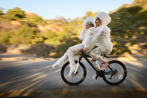 zwei Menschen fahren auf einem Fahrrad mit Luftpolster umwickelt