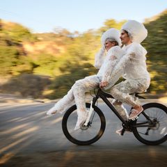 zwei Menschen fahren auf einem Fahrrad mit Luftpolster umwickelt