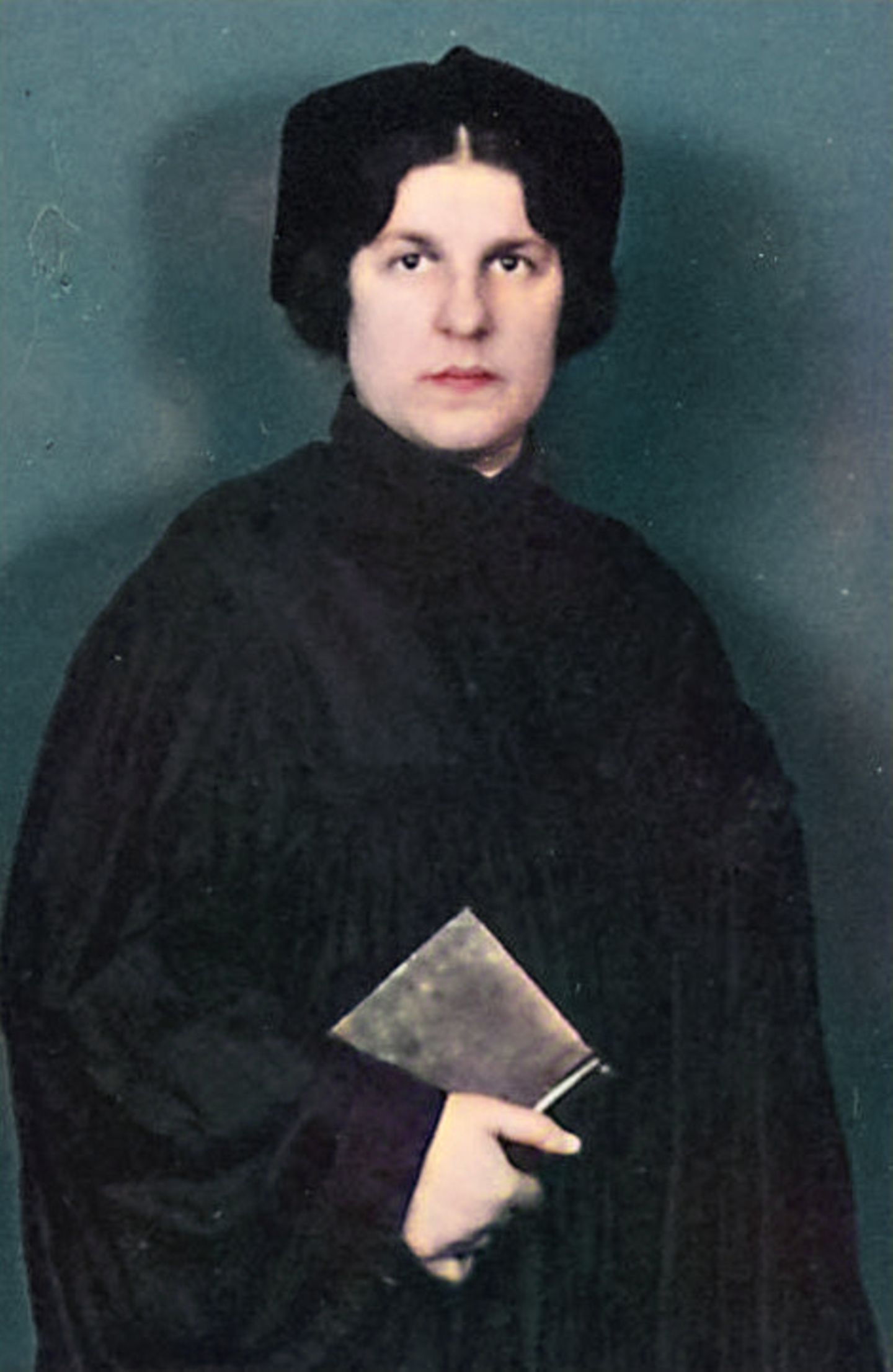 Die Rabbinern – Regina Jonas altes Farbfoto einer Frau in der Kleidung einer Rabbinerin mit einem Buch in der Hand