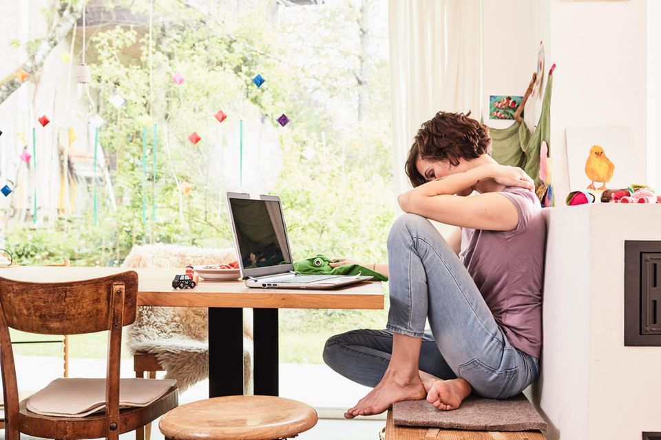 Frau im Stress sitzt am Tisch