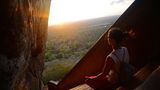 Frau sitzt auf den Stufen bei Sigiriya