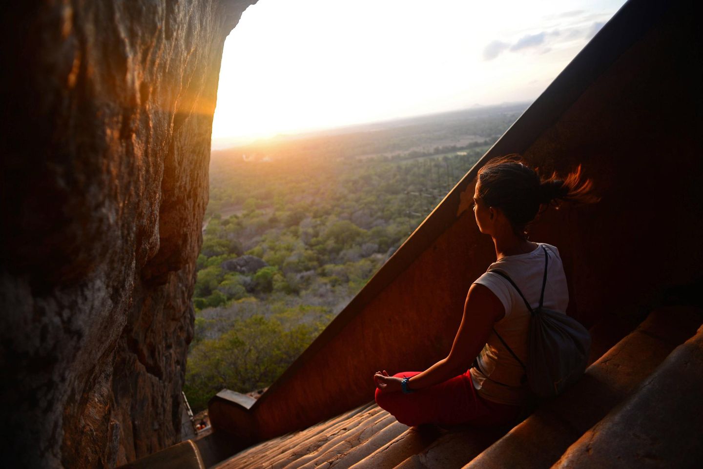 Mit Meditation zu innerer Ruhe finden Frau sitzt auf den Stufen bei Sigiriya