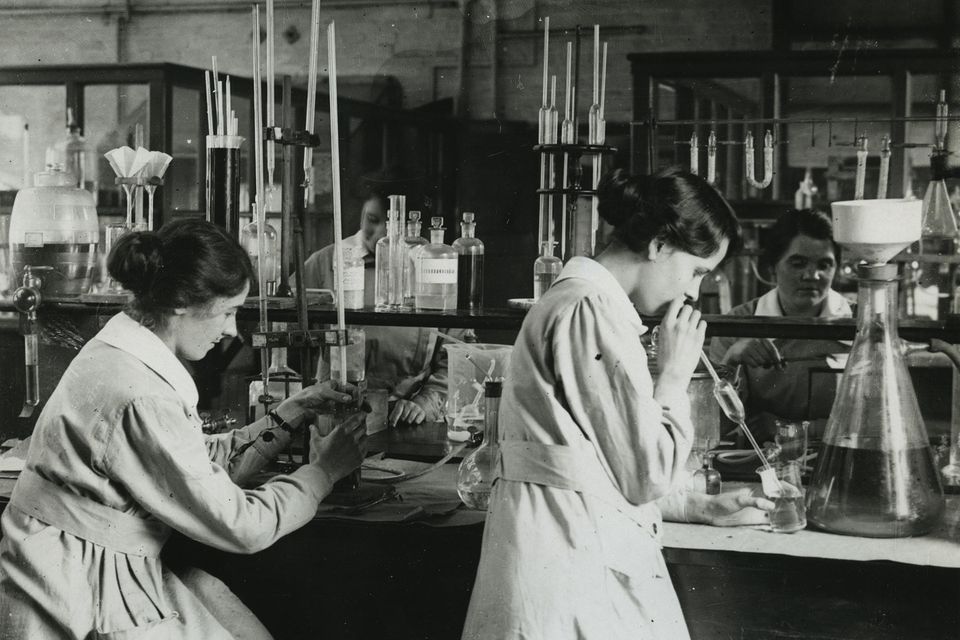 altes Foto von zwei Laborantinnen mit dunklen hochgesteckten Haaren, die in einem Labor arbeiten
