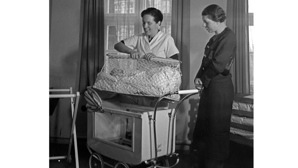 Frau hebt Kind aus Kinderwagen