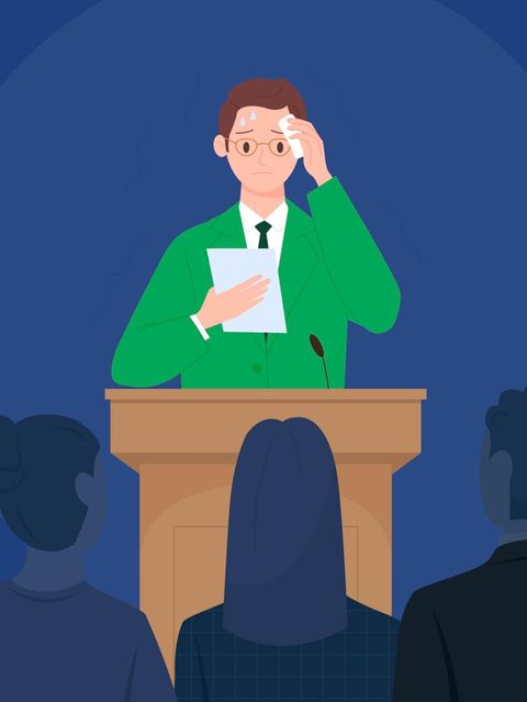 Ein schwitzender Mann steht an einem Podium vor Publikum